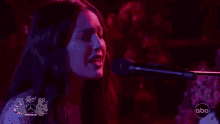 a woman is playing a piano in front of a crowd .