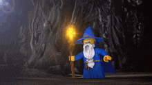 a lego wizard with a beard is holding a torch in a dark cave