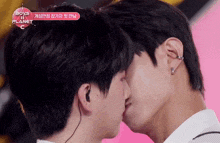 two men kissing with a boys planet logo in the background