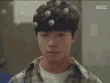 a close up of a young man 's face with mbc written on the bottom of the screen