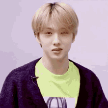 a close up of a person wearing a black sweater and a neon green shirt .