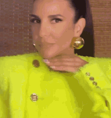 a woman wearing a neon yellow jacket and earrings