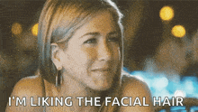 a woman with blonde hair is smiling and says i 'm liking the facial hair .