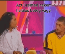 a man in a yellow shirt is talking to a woman in a white shirt on a television show