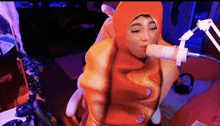 a person wearing an orange costume is sitting in front of a microphone