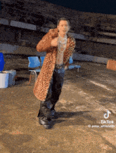 a man in a leopard print coat is dancing on a roof