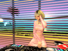 a woman in a pink dress is standing behind a dj controller