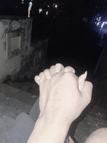a man and woman holding hands in the dark