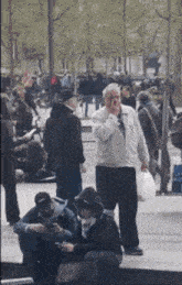 a man in a white jacket is smoking a cigarette in front of a crowd of people