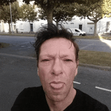 a man making a funny face with a white van in the background that says ' lg ' on it