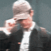 a blurry picture of a man wearing a baseball cap and a jacket