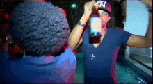 a man wearing a ny hat is holding a bottle in his hand