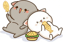 two cats are laying on the floor eating a hamburger and fish .