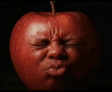 a red apple with a face on it making a funny face