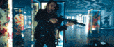 a man is holding a gun in a room with a sign that says ' i 'm sorry ' on it