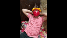 a person with red paint on their face is laying on a bed with their hands behind their head .