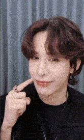 a close up of a person making a funny face with their finger .