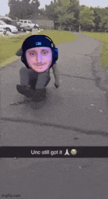 a man wearing headphones is riding a skateboard down a street with the caption " unc still got it a "