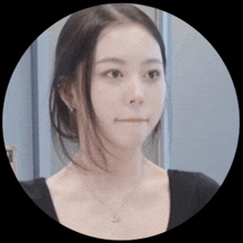 a woman wearing a black shirt and a necklace with a heart pendant