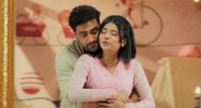 a man and a woman are hugging each other in a room .