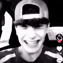a man wearing a baseball cap is laughing in a car .