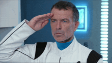 a man in a white and blue uniform salutes
