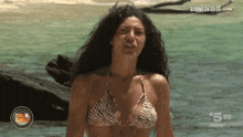 a woman in a zebra print bikini is standing in the water with giorno 24 25 26 written on the bottom