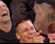 a group of men are laughing together and pointing at each other .