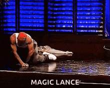 a man is laying on the floor with a sign that says magic lance