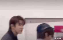 a blurry picture of a man standing next to another man .