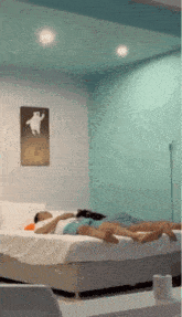 two people laying on a bed in a room with a picture of a polar bear on the wall