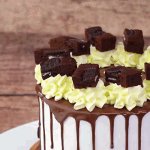 a cake with brownies and whipped cream on top of it