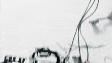 a blurred image of a white background with a few wires hanging off of it
