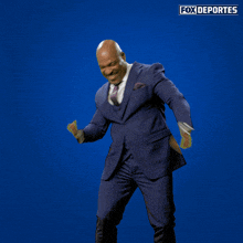 a man in a suit and tie is dancing in front of a fox deportes sign