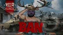 a man without a shirt is wearing a deer head on his head in front of a tank .