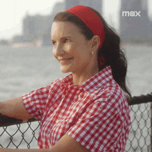 a woman wearing a red headband and a red and white checkered shirt with the word max on the bottom