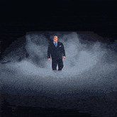 a man in a suit and tie is standing in a foggy room