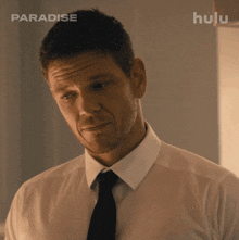 a man in a white shirt and black tie with hulu written on the bottom