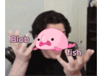 a man is holding a pink blob in front of his face