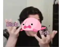 a man is holding a pink blob in front of his face