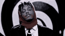 a man in a suit and tie is wearing a head scarf .