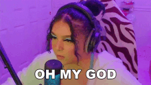 a woman wearing headphones is sitting in front of a microphone and saying oh my god .