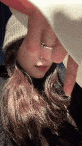 a woman wearing a ring covering her face with her hand