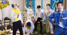 a group of people are dancing in a room with a sign that says ' uiu tv ' on it