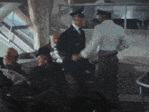 a man in a white shirt shakes hands with a man in a black uniform