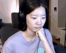 a woman wearing headphones and a purple shirt with a mermaid on it