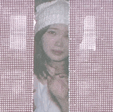 a woman wearing a white hat is peeking through a screen door