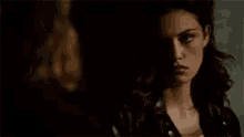 a woman is standing in a dark room looking at another woman .