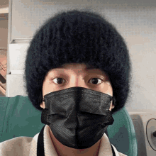 a person wearing a black face mask and a beanie