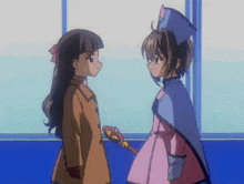 two anime girls are standing next to each other and one of them is holding a wand